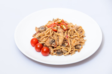 Wok food on a white ceramic plate is tasty and fresh with sauce on a light isolated background