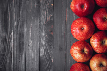 Dark wooden background with red apples on the right side of the frame