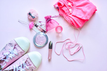 pink girl: Pink sneakers, t-shirt, brooch, cosmetics and headphones on a pink background