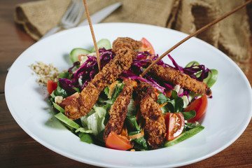 Delicious salad with chicken, nuts, egg and vegetables.
