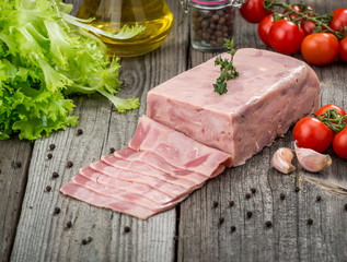 Cut sausage from ham on a wooden background