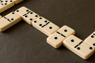 A game of dominoes on a dark table . The concept of the game of dominoes. Close up