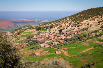 A small settlement in the Atlas Mountains. The mountain range is covered with bright green...