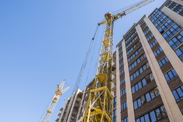 Fototapeta na wymiar Construction of a high-rise building with a crane. Building construction using formwork. Cranes and buildings against the blue sky.