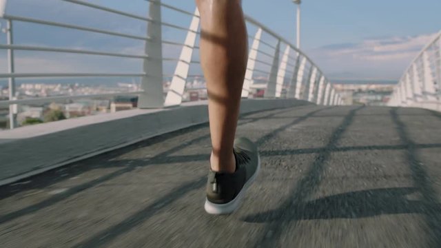 close up male athlete legs running sprinting fast in urban city at sunrise training workout