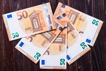 Euro banknotes on a brown wooden background