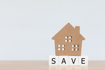 House model and wooden cubes with alphabet SAVE on wooden table. Concept for property, ladder, mortgage ,real estate investment and saving
