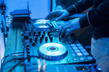 DJ plays and mix music on digital mixer controller. Close-up DJ performance controller, digital...
