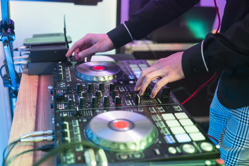Fototapeta na wymiar DJ plays and mix music on digital mixer controller. Close-up DJ performance controller, digital midi turntable system, adjustable torque, aluminum-turntable platter, fader, knob and slider, button.
