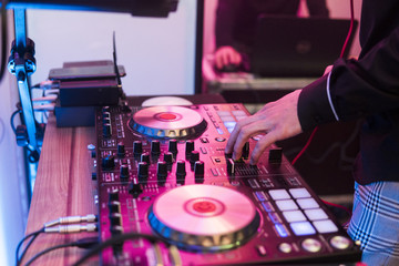 Fototapeta na wymiar DJ plays and mix music on digital mixer controller. Close-up DJ performance controller, digital midi turntable system, adjustable torque, aluminum-turntable platter, fader, knob and slider, button.