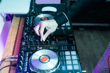 DJ plays and mix music on digital mixer controller. Close-up DJ performance controller, digital...