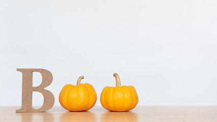 Pumpkin with alphabet BOO on wood table with white background. Halloween and decoration concept