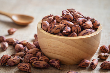 Roasted striped peanuts in wooden bowl