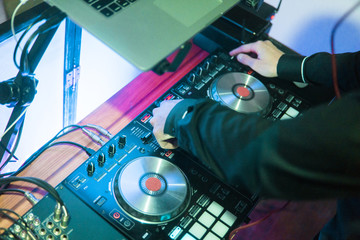 DJ plays and mix music on digital mixer controller. Close-up DJ performance controller, digital...