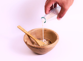 Muesli into wood bowl and milk