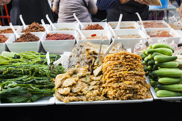 Fried fish in batter, fresh vegetables on street market, Thailand