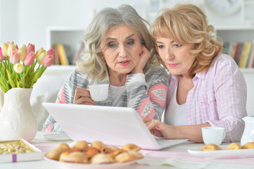 two senior women drinking tea at home