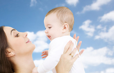 family and motherhood concept - happy smiling young mother with little baby over sky background