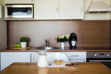 Fototapeta na wymiar milk, corn flakes and cookies in modern kitchen