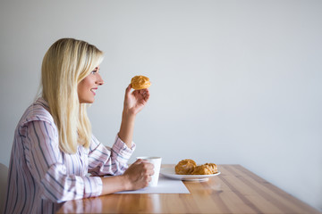Fototapeta premium breakfast or coffee break concept - woman drinking coffee with pastry at home