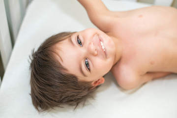 Obraz na płótnie Canvas Cute baby boy toddler - in the crib - lying and smiling.