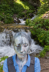 Girl Office worker, outdoors with a makeup on her face imitating a mountain stream. The girl merges...