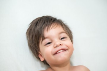 Cute baby boy toddler - in the crib - lying and smiling.