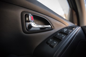 Obraz premium Closeup of a Door Control Panel and Handle in a Modern Car