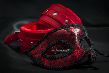 BDSM, bondage play, fetish wear and kinky sex toy concept with close up on erotic mask and red...