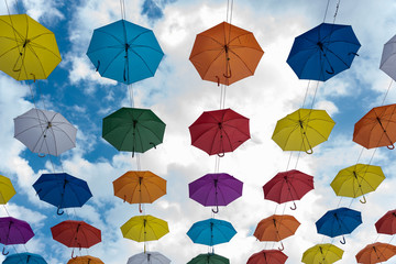 Multicolored umbrellas hanging high above the ground