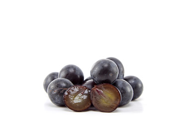 Fresh black grapes on white