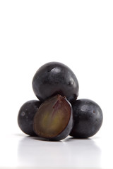 Fresh black grapes on white
