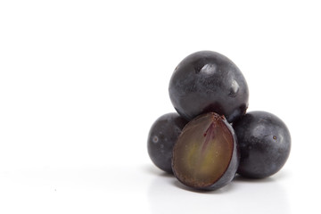 Fresh black grapes on white