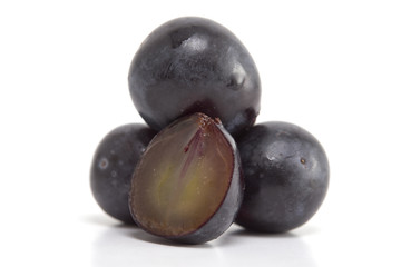 Fresh black grapes on white
