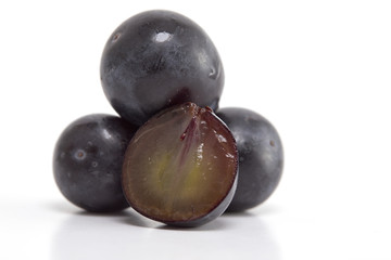 Fresh black grapes on white
