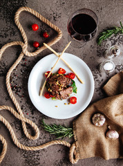Sliced prime ribeye steak on black stone plate.