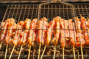 Raw pieces of pork meat on metal grill