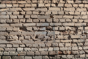 Old yellow brick wall weathered by time