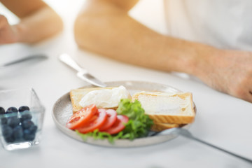 food, eating and breakfast concept - toasts with poached egg and vegetables on plate