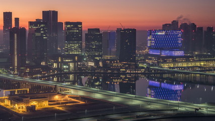 Abu Dhabi city skyline with skyscrapers before sunrise from above night to day timelapse
