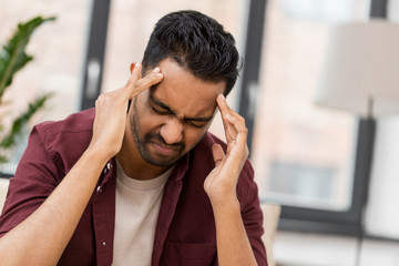 people, crisis, emotions and stress concept - unhappy man suffering from head ache at home