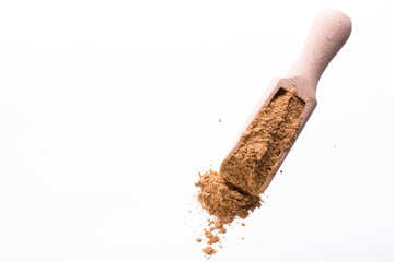 Dry yellow clay mask for face and body in a wooden spoon. Isolated on a white background