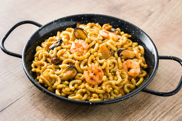 Traditional Spanish fideua. Noodle paella on wooden table