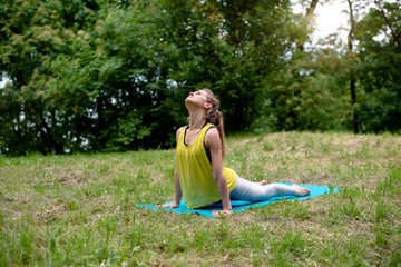 Young woman doing yoga exercise Bhujangasana (cobra pose)