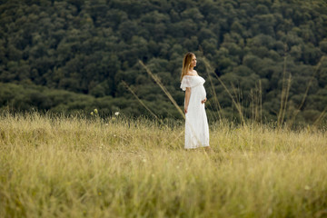 Young pregnant woman relaxing outside in nature