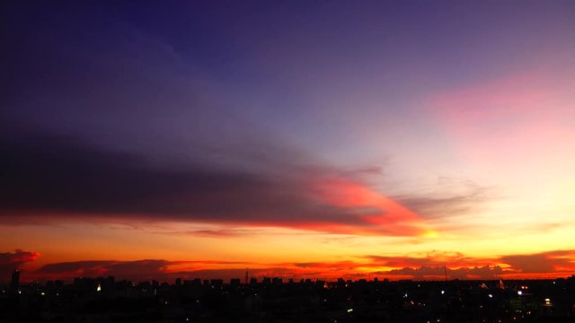  4K orange sunset as the massive sun sets into the horizon above the city