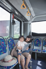 woman is holding her daughter in her lap and showing tablet on t © Odua Images