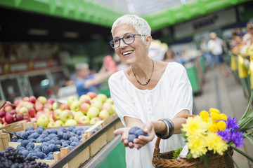 Senior woman buying fruit on market
