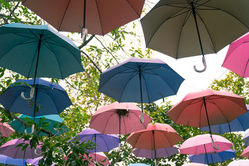 Fototapeta na wymiar The sky of colorful umbrellas background.Street decoration.Colorful Hanging Umbrellas