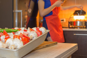 prepares healthy food in the kitchen. Cooking skewered mushrooms, Champignon process with...